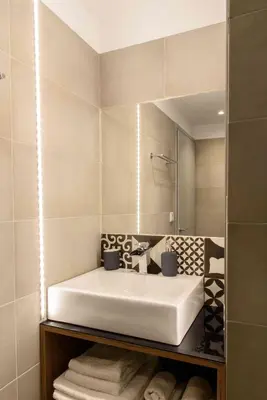 a bathroom with a white sink and a mirror at Electra & Myrto Apartments in Athens