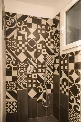 a bathroom with a black and white tiled wall at Electra & Myrto Apartments in Athens