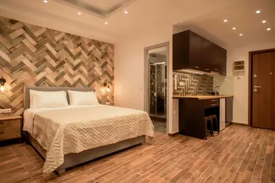 a bedroom with a bed and a desk and a kitchen at Electra & Myrto Apartments in Athens