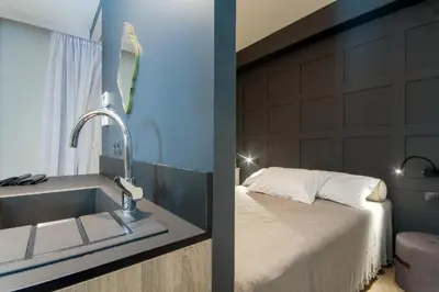 a bathroom with a sink next to a bed at Comfort studios in Kolonaki in Athens