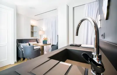 a kitchen with a sink and a living room at Comfort studios in Kolonaki in Athens