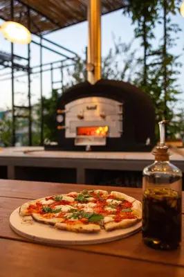 a pizza sitting on a table in front of an oven at The Foundry Suites in Athens