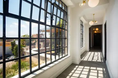 a hallway with large windows looking out at a city at The Foundry Suites in Athens