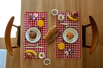 a table with plates of food on a red and white table cloth at The Foundry Suites in Athens