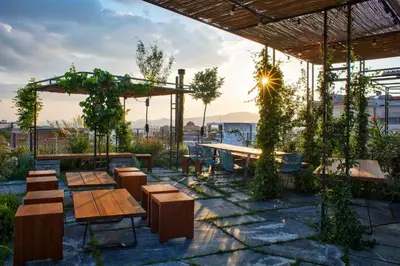 a patio with wooden tables and chairs and a table at The Foundry Suites in Athens