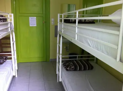 a room with two bunk beds and a green door at Zeus Hostel in Athens