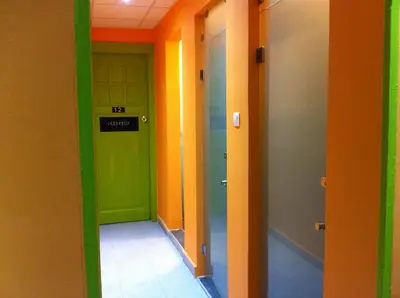 a hallway with different colored walls and doors at Zeus Hostel in Athens
