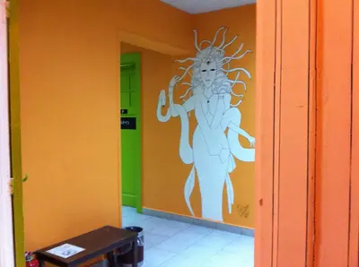 a wall with a painting of a woman on a wall at Zeus Hostel in Athens