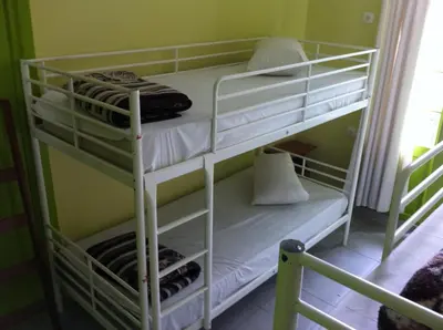 a bunk bed with white bunk beds in a room at Zeus Hostel in Athens