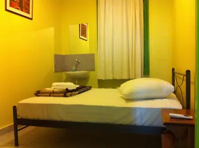 a bed with pillows and a sink in a room at Zeus Hostel in Athens