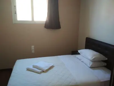 a bedroom with a bed with white sheets and pillows at Pella Inn Hostel in Athens