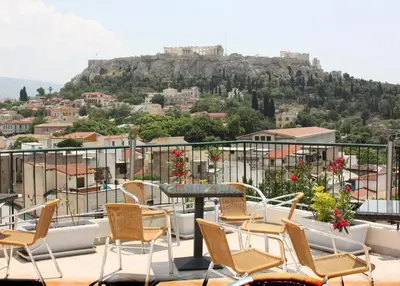 a table and chairs on a balcony with a view at Pella Inn Hostel in Athens