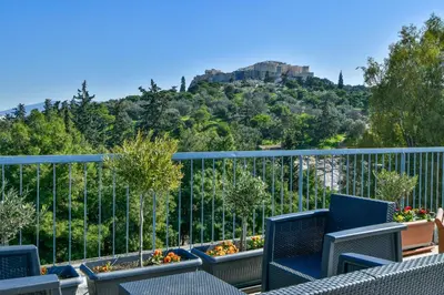 a balcony with chairs and a view of the acropolis at Athens Memory in Athens