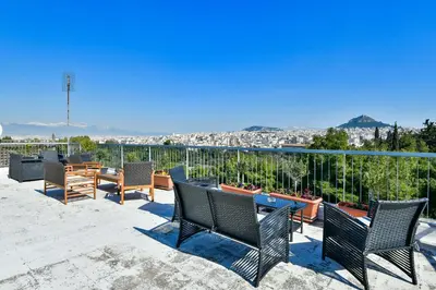 a patio with chairs and tables and a view of a city at Athens Memory in Athens