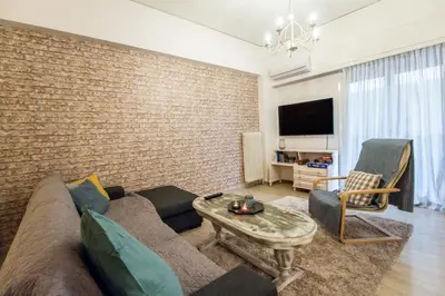 a living room with a couch and a brick wall at Stylish apt in Athens center in Athens