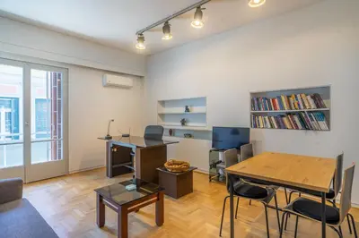 a living room with a table and a desk at Charming and renovated flat in the heart of Athens in Athens