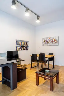 a living room with a table and chairs in a room at Charming and renovated flat in the heart of Athens in Athens
