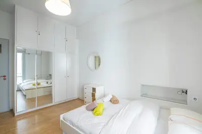 a white bedroom with a bed and a mirror at Charming and renovated flat in the heart of Athens in Athens
