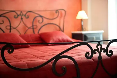 a bed with red sheets and red pillows on it at Marble House in Athens