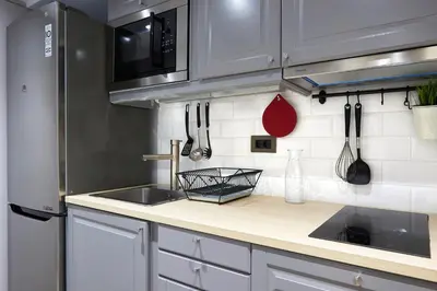 a kitchen with white cabinets and a sink at Marble House in Athens