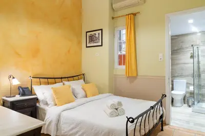 a bedroom with a bed and a desk and a window at Marble House in Athens