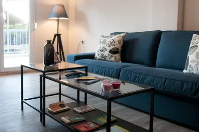 a living room with a blue couch and a table at TONI'S 2BD Gem House near Plaka and Syntagma in Athens