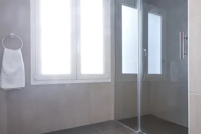 a bathroom with a shower and a window and a towel at TONI'S 2BD Gem House near Plaka and Syntagma in Athens