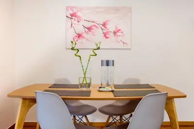 a dining room table with chairs and a vase with flowers at TONI'S 2BD Home in Centre, 15 sec to Metro in Athens