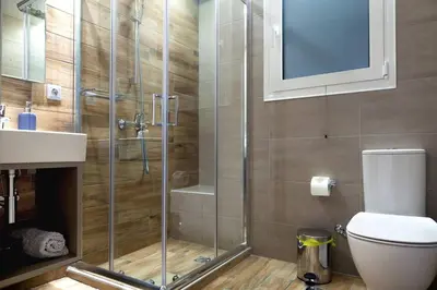 a bathroom with a shower and a toilet and a sink at TONI'S 2BD Home in Centre, 15 sec to Metro in Athens