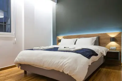 a bedroom with a large bed with white sheets at TONI'S 4BD near Classy KOLONAKI, locals enjoy it in Athens