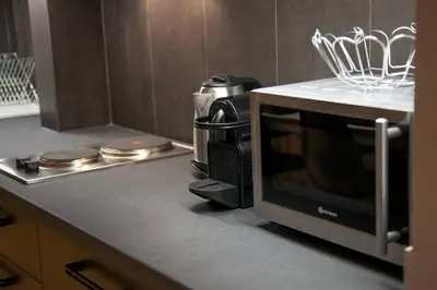 a microwave oven on a counter in a kitchen at TONI'S 4BD near Classy KOLONAKI, locals enjoy it in Athens