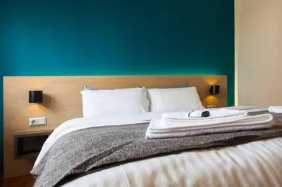 a bedroom with a bed with a green wall at TONI'S Brand-New Studio next to Syntagma Square in Athens
