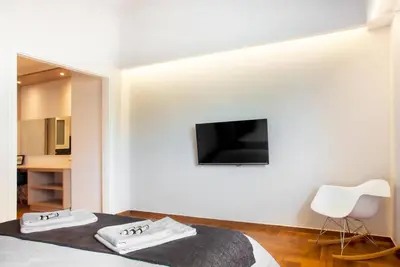 a bedroom with a bed with a tv on the wall at TONI'S Brand-New Studio next to Syntagma Square in Athens