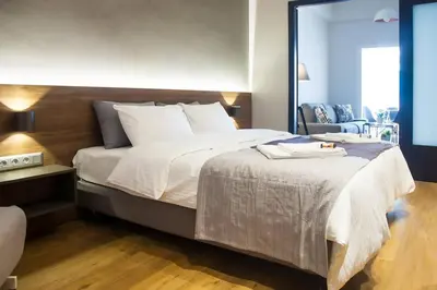 a bedroom with a large bed with white sheets at TONI'S Charming Apartment 2BD, close Thisseo Metro in Athens