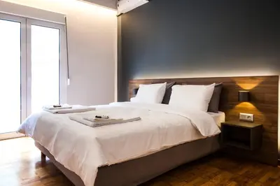 a bedroom with a large bed with white sheets and pillows at TONI'S Charming Apartment 2BD, close Thisseo Metro in Athens