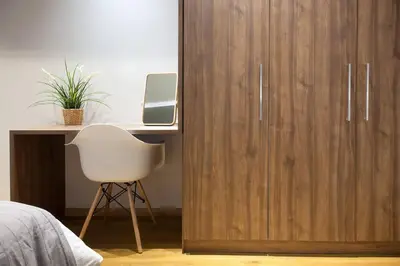 a bedroom with a wooden cabinet and a desk with a white chair at TONI'S Charming Apartment 2BD, close Thisseo Metro in Athens