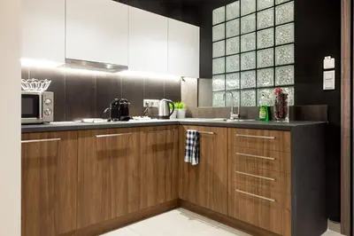 a kitchen with wooden cabinets and a microwave at TONI'S Charming Apartment 2BD, close Thisseo Metro in Athens