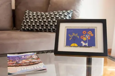 a picture frame on a table next to a book at TONI'S Classy Home in Kolonaki, local's Gem in Athens