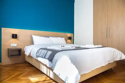 a bedroom with a large bed with a blue wall at TONI'S Classy Home in Kolonaki, local's Gem in Athens