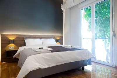 a bedroom with a large bed and a large window at TONI'S Charming Apartment in the Thisseo station in Athens