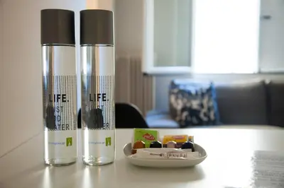 two water bottles on a table with a bowl of medicines at TONI'S Charming Apartment in the Thisseo station in Athens