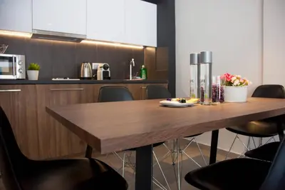 a kitchen with a wooden table and some chairs at TONI'S Comfy 3BD home with patio, close to Metro in Athens