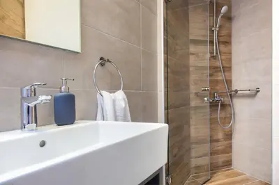 a bathroom with a white sink and a shower at TONI'S Comfy 3BD home with patio, close to Metro in Athens