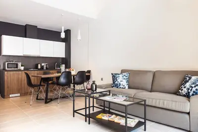a living room with a couch and a table at TONI'S Comfy 3BD home with patio, close to Metro in Athens