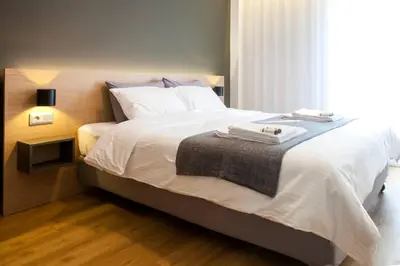 a bedroom with a large white bed with a window at TONI'S Comfy home near Acropolis with Small Garden in Athens