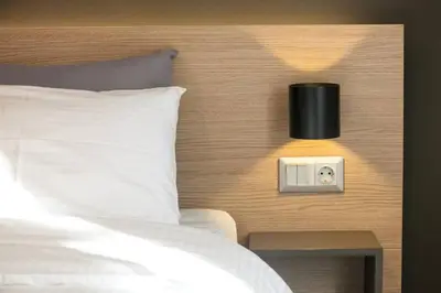 a bedroom with a bed and a night stand with a clock at TONI'S Comfy home near Acropolis with Small Garden in Athens