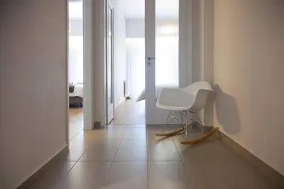 a white chair sitting on a tiled floor in a room at TONI'S Comfy home near Acropolis with Small Garden in Athens