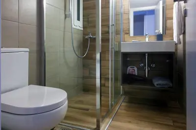 a bathroom with a toilet and a sink and a shower at TONI'S Comfy home near Acropolis with Small Garden in Athens