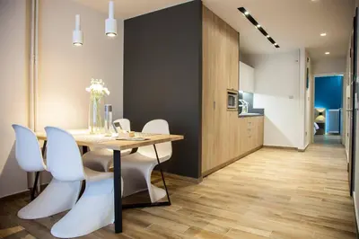 a dining room with a table and white chairs at TONI'S Cosy Apartment next to Syntagma Square in Athens