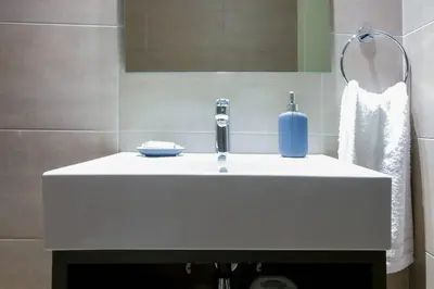a bathroom sink with a blue soap bottle on it at TONI'S Home for couples or business Travellers 1BD in Athens